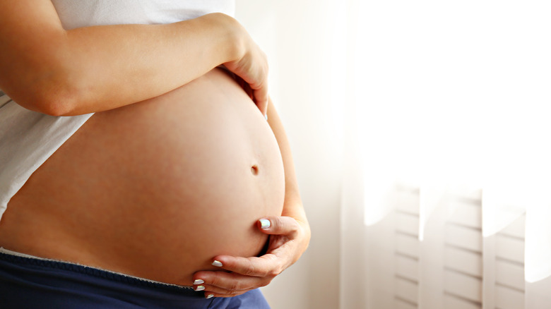 Woman holding pregnant belly