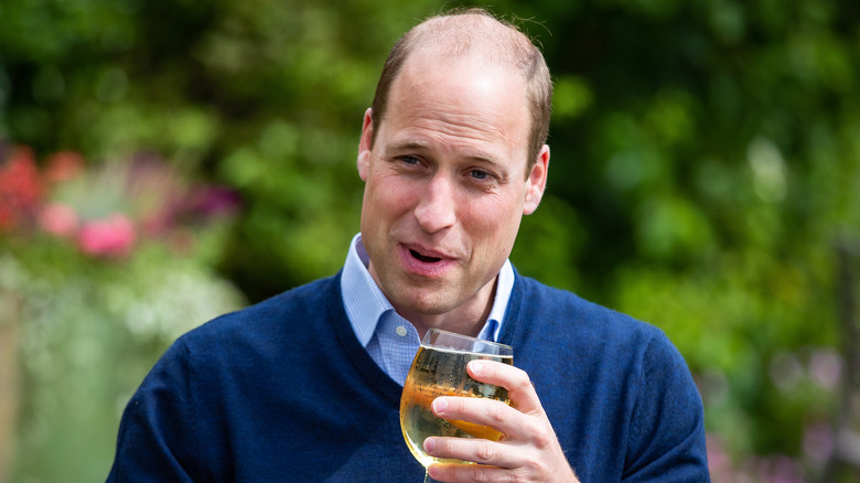 Prince William holding a glass