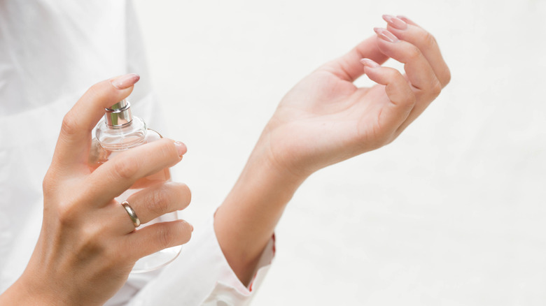 Woman spraying perfume on her wrist