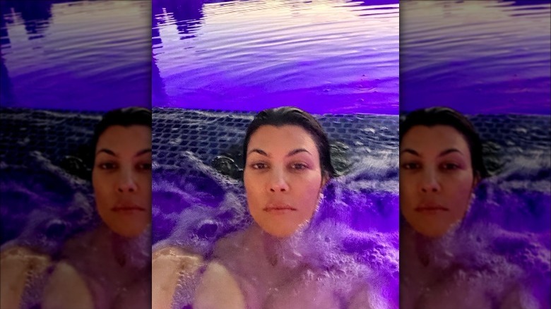 Kourtney Kardashian makeup-free sitting in a hot tub