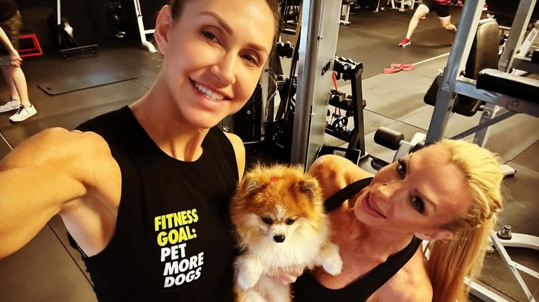 Lara Trump, Pomeranian dog, and friend pose in gym