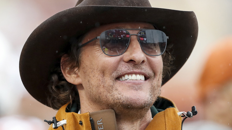 Matthew McConaughey wearing sunglasses and a cowboy hat at a UT Austin game 