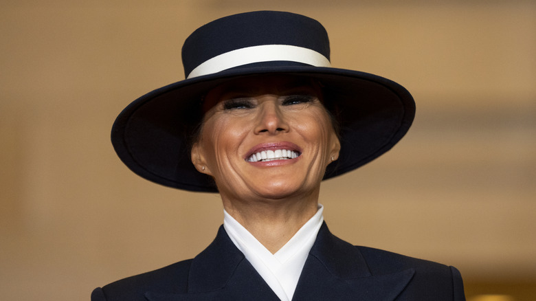 Melania Trump grinning in a hat