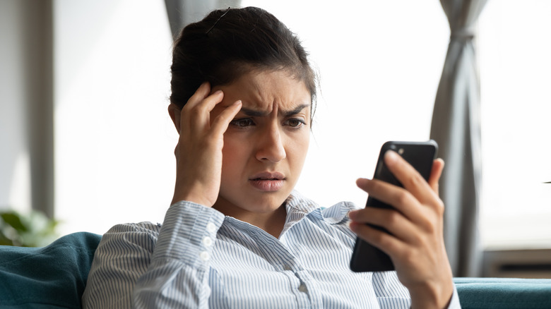 Unhappy woman looking at phone 