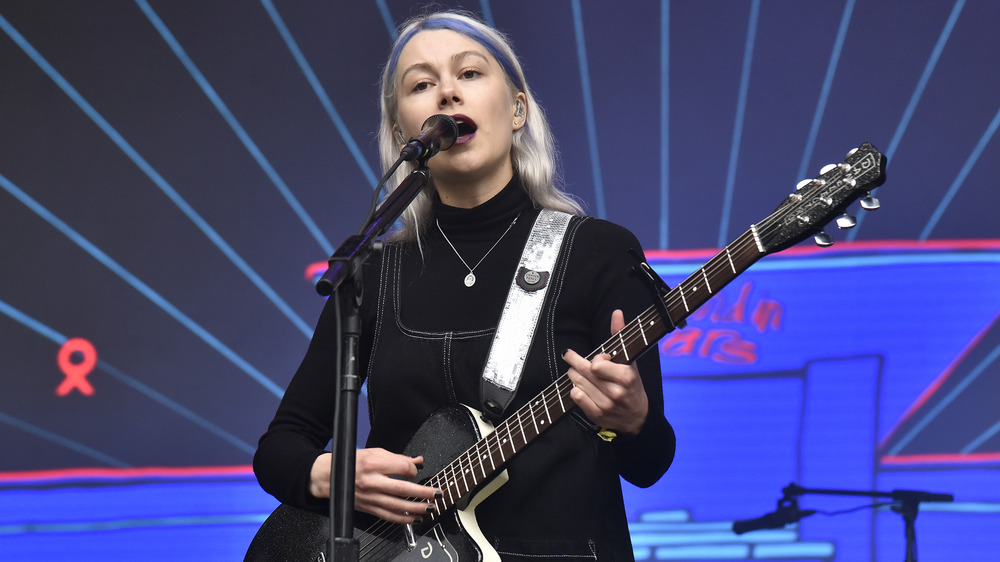 Phoebe Bridgers singing and playing guitar