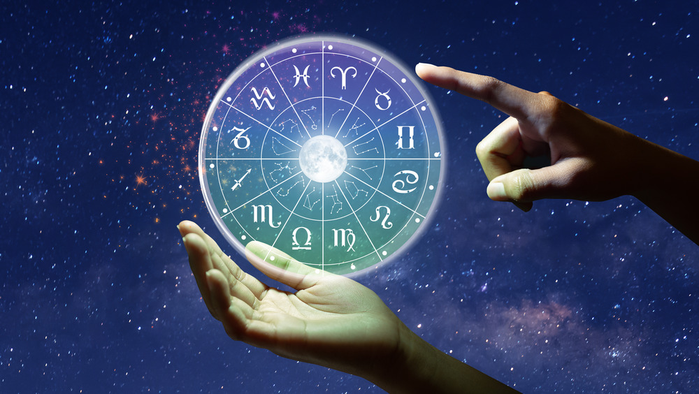 Symbol of the zodiac with a hand pointing to it 