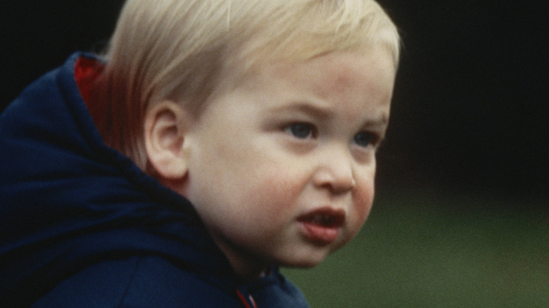 A young Prince William wearing a blue hooded jacket