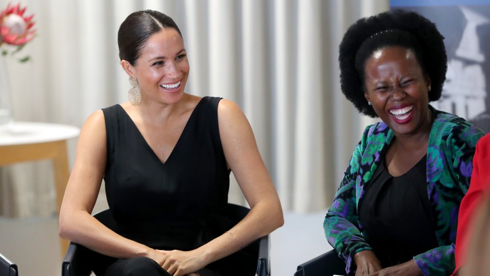 Meghan Markle laughing while chatting