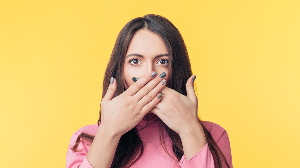 woman covering mouth