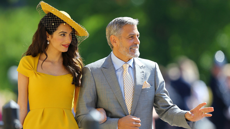 Amal and George Clooney looking over at something in the distance