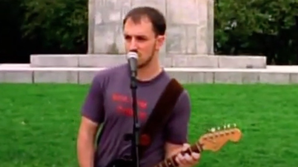Steve Burns playing the guitar outside