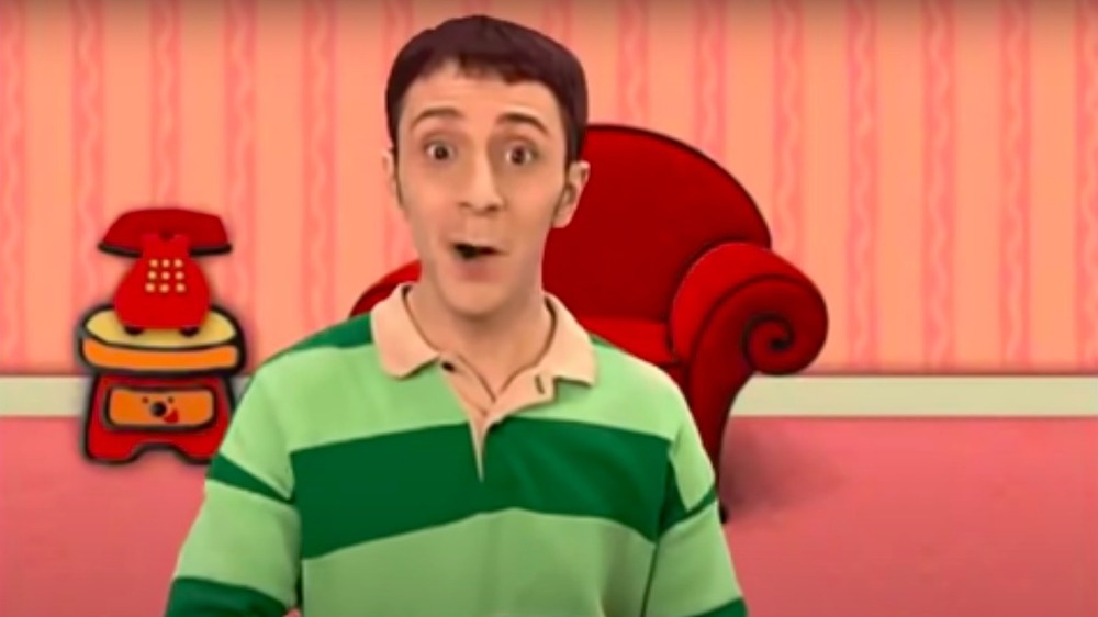 Steve Burns in front of a red chair and phone on Blue's Clues