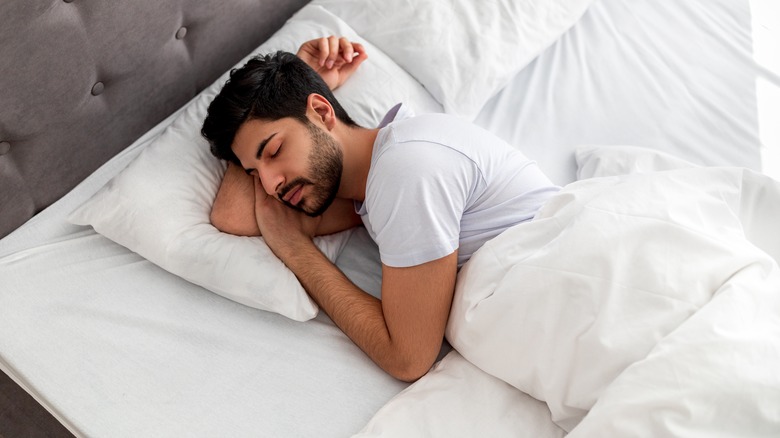 Man sleeping on white sheets