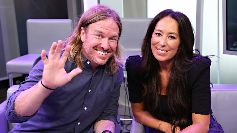 Joanna and Chip Gaines wave and smile at camera