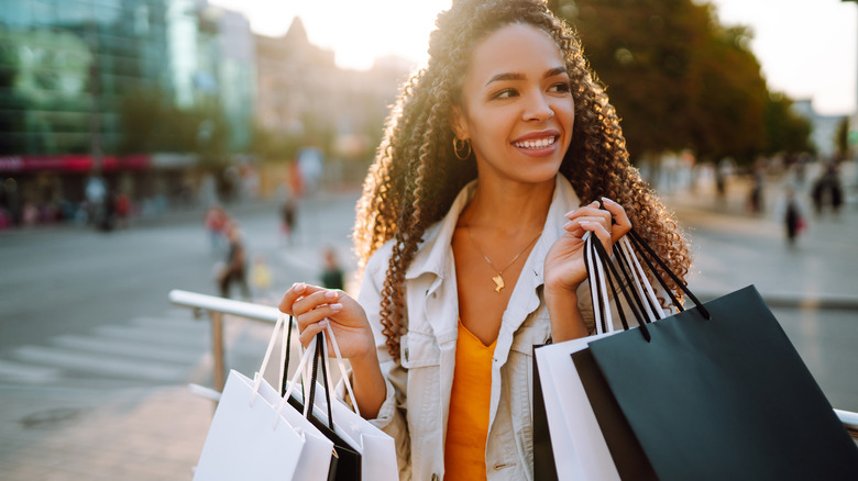 woman with shopping bags walking on street