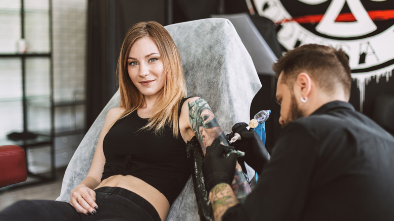 Woman getting tattoo