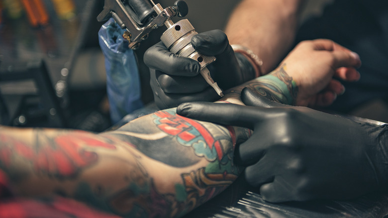 Woman getting a tattoo on her arm