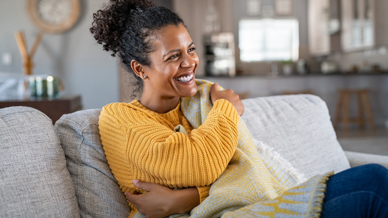 Woman hugs herself and smiles