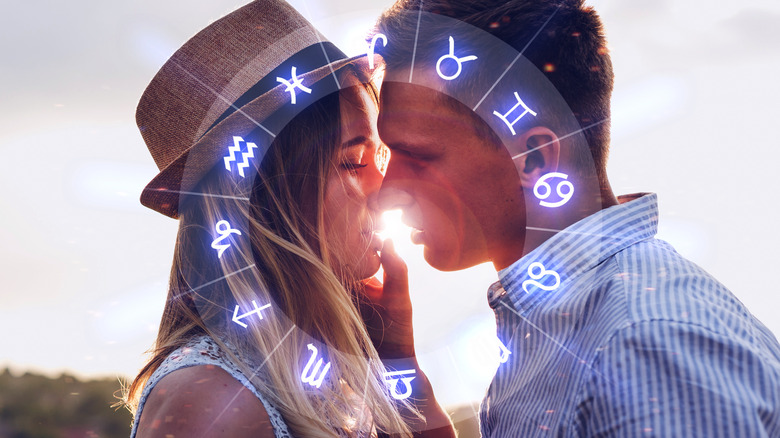 Couple kissing with astrological signs in foreground