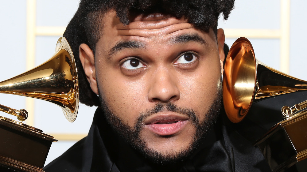 The Weeknd holding two Grammys