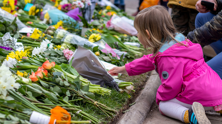 Child leaving flowers for Queen Elizabeth at Windsor Castle