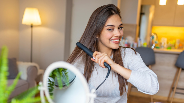 A woman straightening her hair