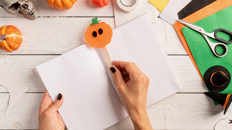 Woman placing DIY Halloween bookmark in a book