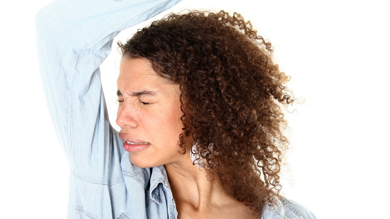 Woman reacting to underarm odor