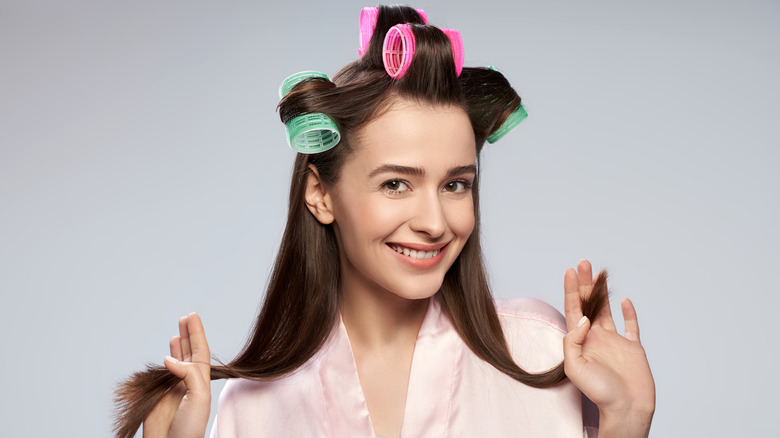 A woman with velcro rollers on smiling