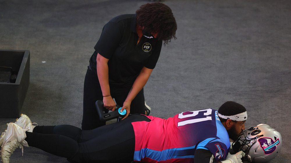 Woman massaging a football player