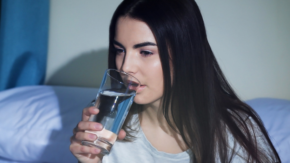 Woman drinking water in bed