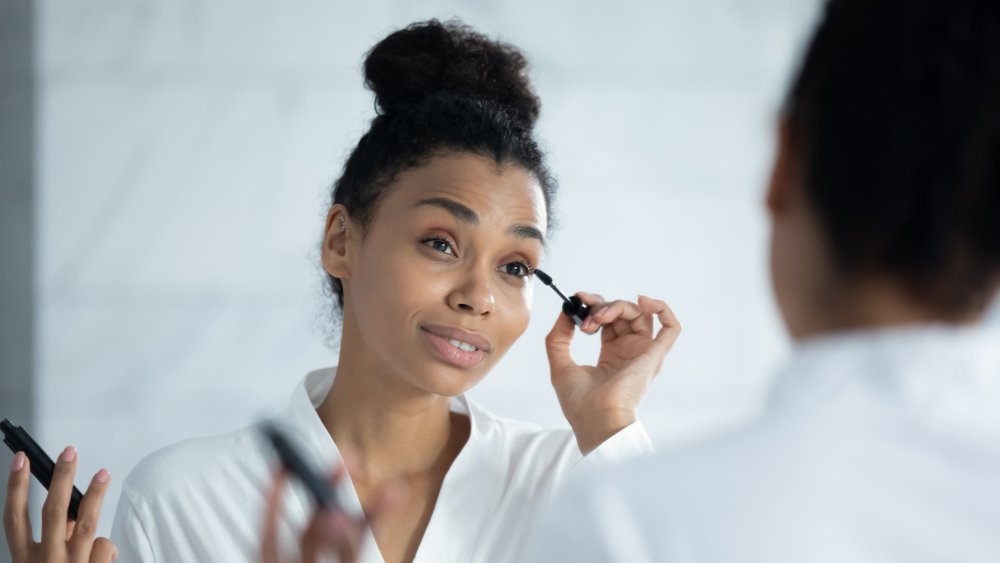 Woman putting on mascara