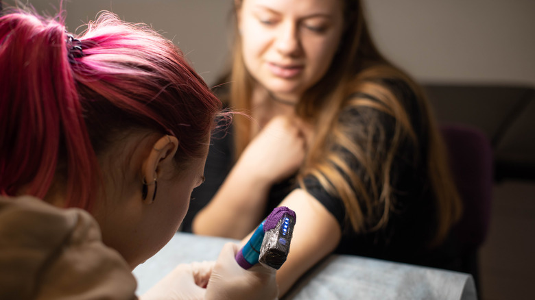 Woman having tattoo fixed