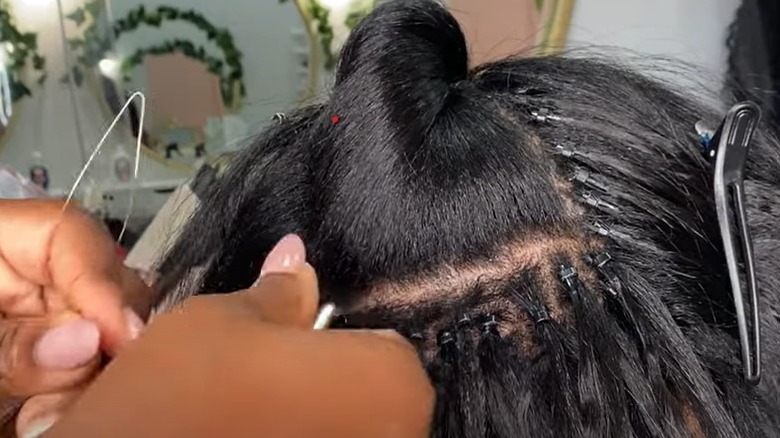 Black woman getting some microlinks for a weave