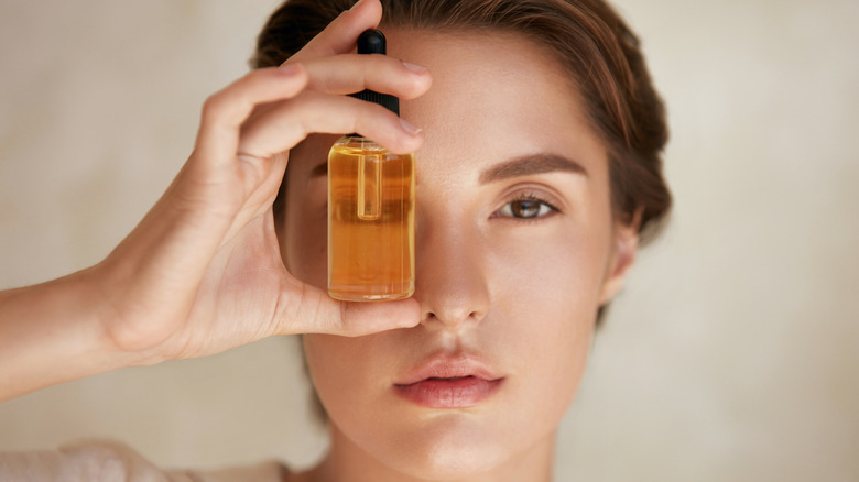 Woman holds facial oil