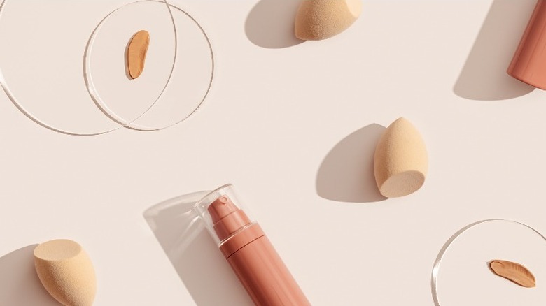 Foundation bottle, beauty sponge, and foundation sample in a petri dish on a table