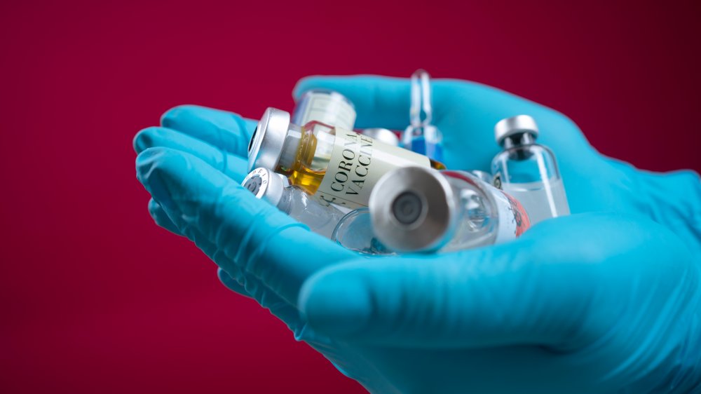 Hand holding vaccine bottles