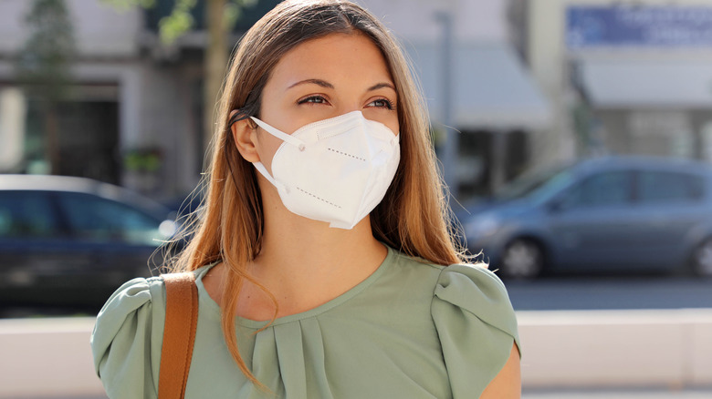 Woman in green shirt wearing KN95 mask