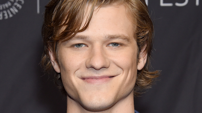 Lucas Till smiling at an event 