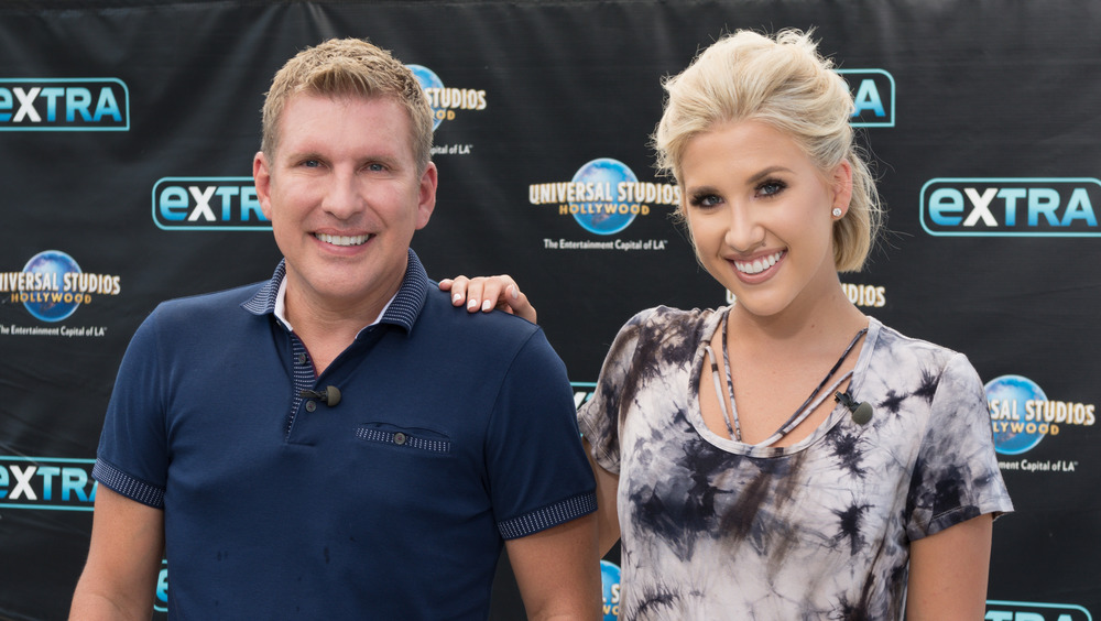 Todd Chrisley poses at an event with his daughter Savannah