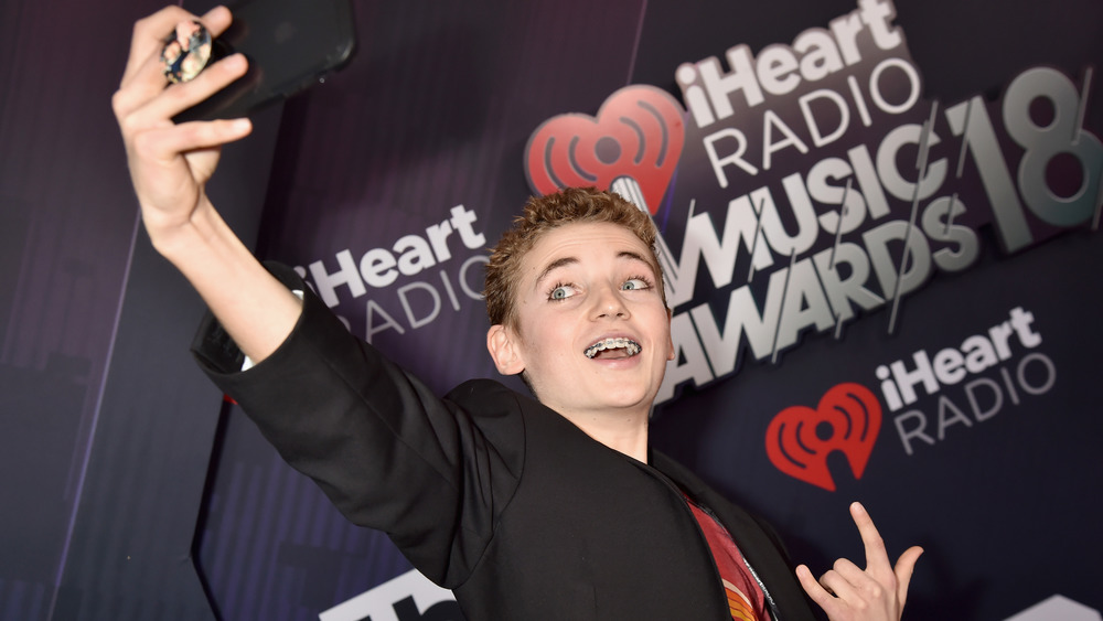 Selfie Kid smiling, with braces on red carpet