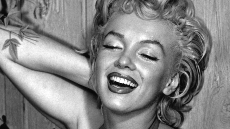 Marilyn Monroe laughing while having her picture taken