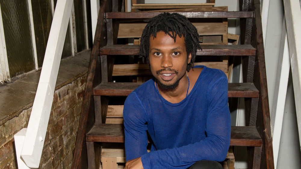 Raury sitting on wooden steps