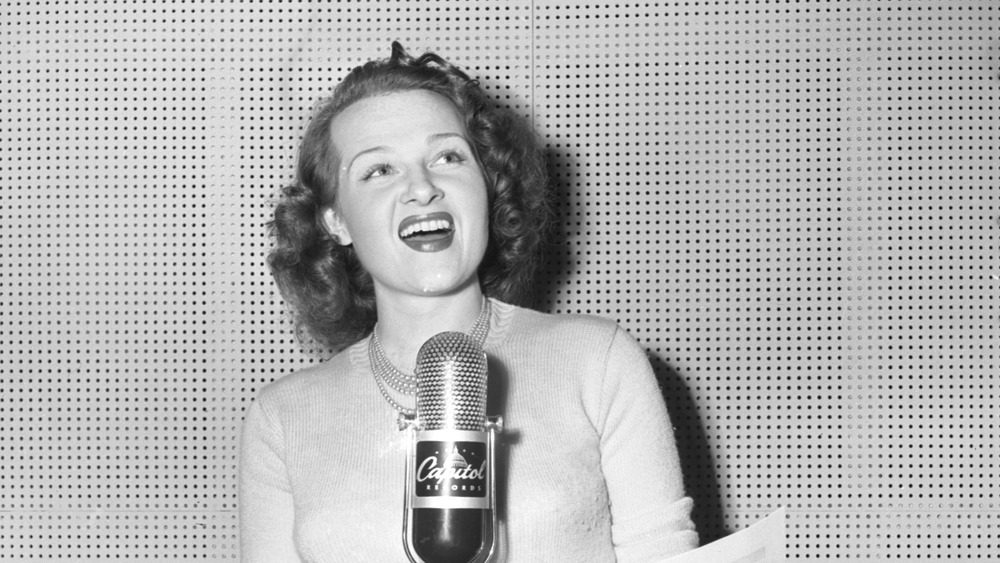 Singer Jo Stafford in front of a microphone 