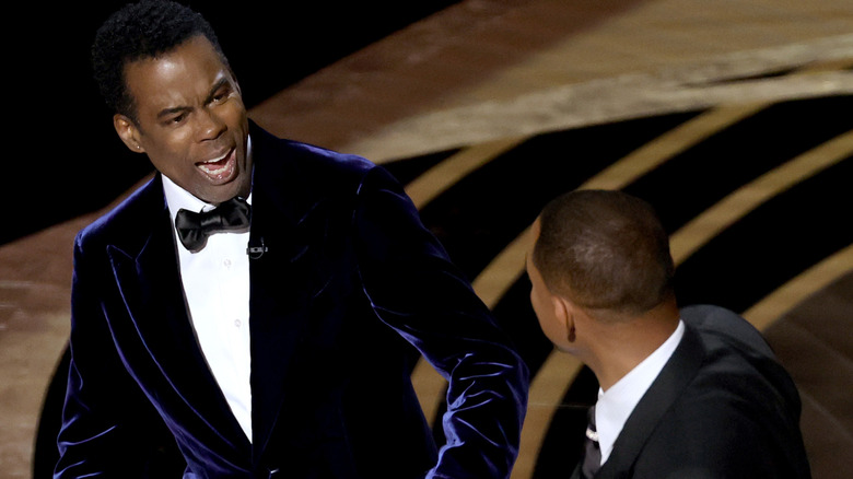 Chris Rock reacts to being slapped by Will Smith at the Oscars