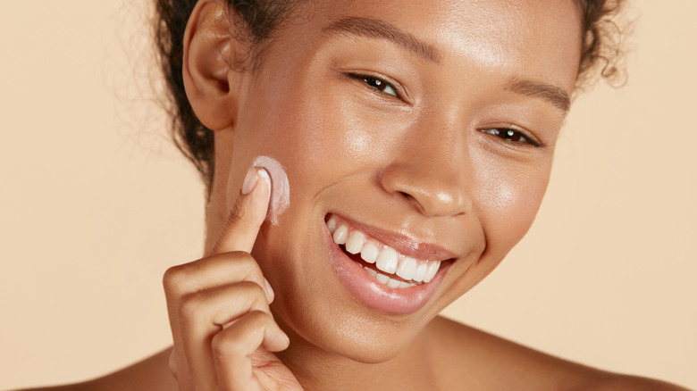 Woman applying moisturizer