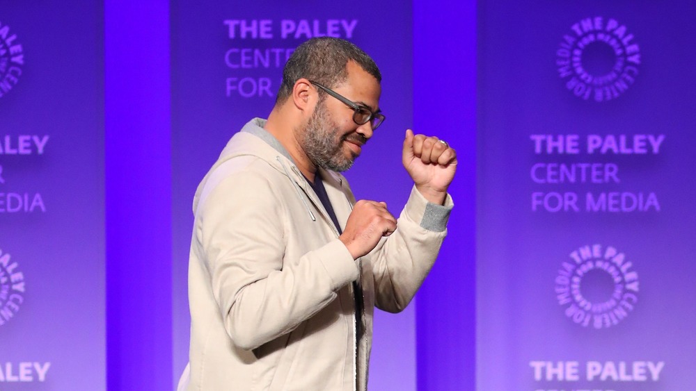 Jordan Peele in tan hoodie at panel