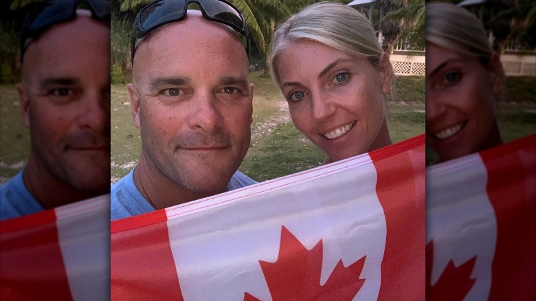 Bryan and Sarah Baeumler hold up a Canadian flag