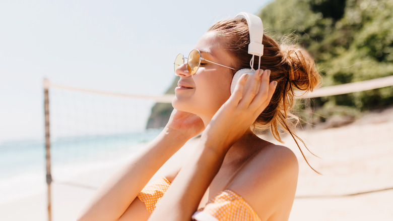 Woman listening to music on a beach 