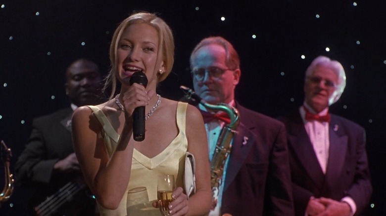 Kate Hudson in a yellow dress standing in front of a band in How To Lose A Guy In 10 Days